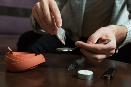 Narcotic dependence man preparing a dose of heroin