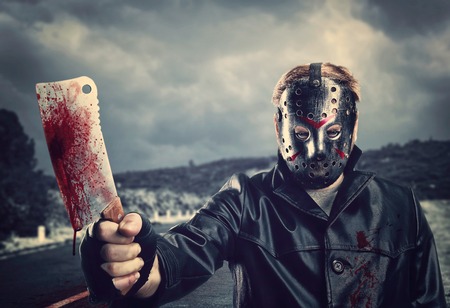 Butcher in hockey mask with bloody meat cleaverの写真素材