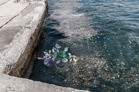 Garbage in water on pier.の写真素材