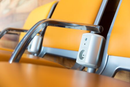Chairs with electric outlet in airport.