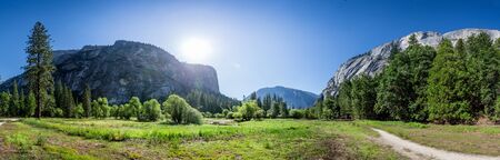 Meadow and trees surrounded by rocky mountains