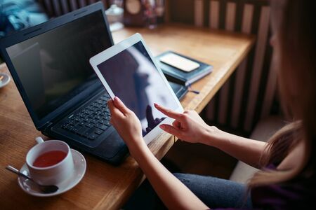 Female using tablet pc in cafeの写真素材