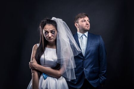 Tear-stained bride and brutal groom in suitの写真素材