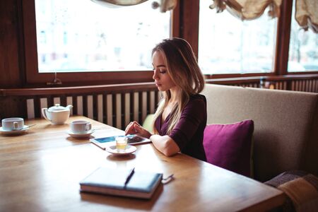 Girl using wifi on tablet pc in cafe.の写真素材