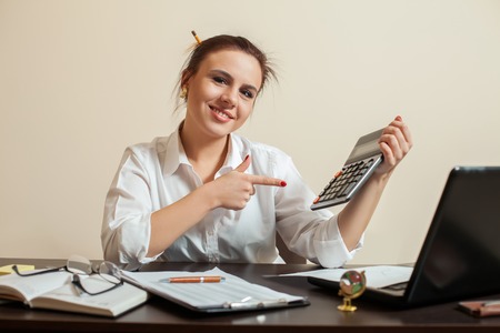 Happy young female accountant with calculatorの写真素材