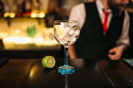 Alcoholic cocktail and lime on wooden counterの写真素材