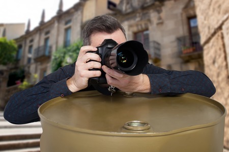 Photographer takes a picture leaning on barrelの写真素材