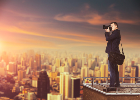 Photographer with digital camera against cityscapeの写真素材