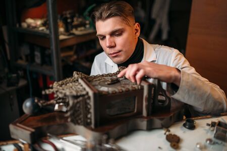 Watchmaker adjusts the mechanism of old wall clockの写真素材