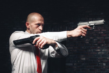 Bald hired killer in red tie aims a pistols