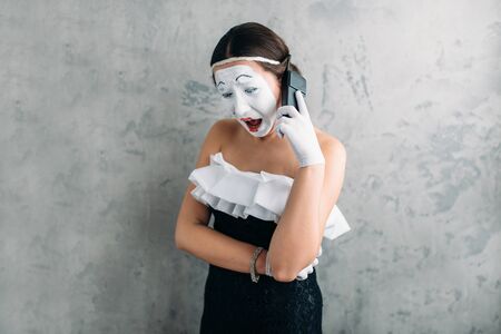 Mime actress performing with mobile phoneの写真素材