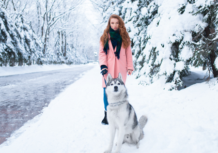 Young woman walks in the park with siberian huskyの写真素材