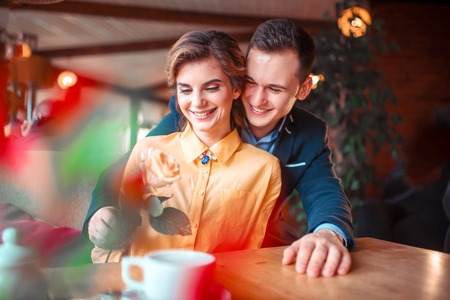 Happy man in suit gives rose to beautiful womanの写真素材