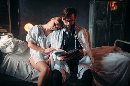 Love couple reading a book in hospital roomの写真素材