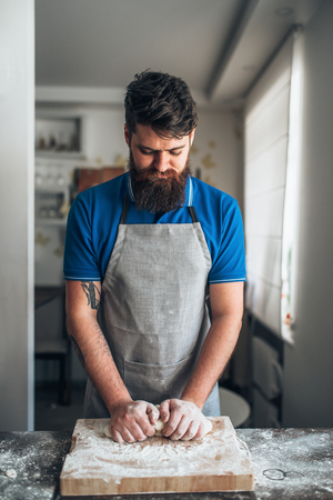 Baker hands kneading the dough with flourの写真素材