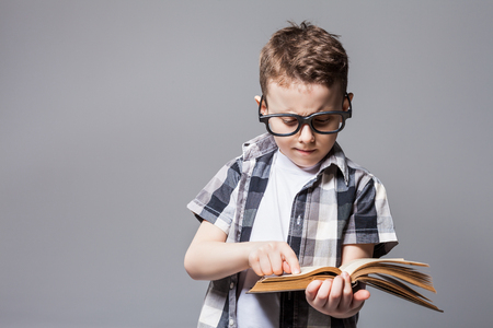 Little child with school bag and book in studioの写真素材