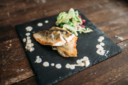 Dish of fried fish decorated with vegetablesの写真素材