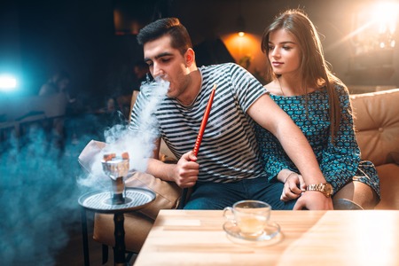 Young couple relax and smoking hookah