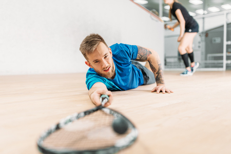 Squash training, player with racket lies on floorの写真素材
