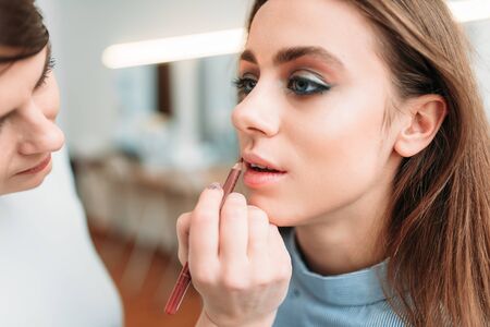 Make up artist hand applying gloss on woman lipsの写真素材