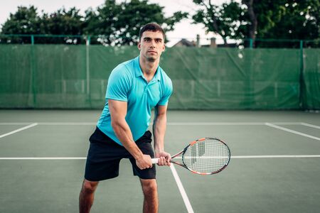 Athletic male tennis player plays on outdoor courtの写真素材