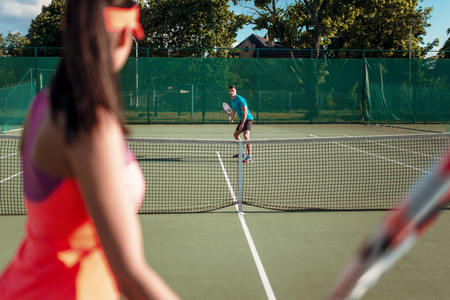 Couple playing tennis on outdoor courtの写真素材