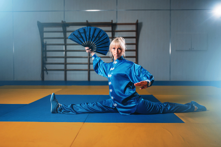 Female wushu master exercise with fan, martial artの写真素材