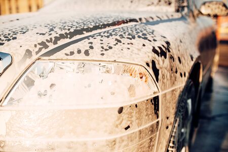 Wet vehicle in foam, automobile in suds, car washの写真素材