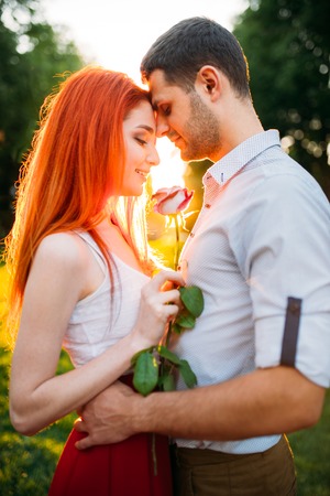 Beautiful love couple hugs in park on sunset