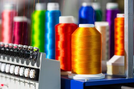 Spools of color threads closeup, spinning machine