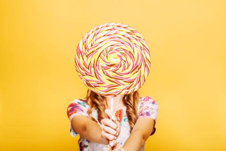 Woman with huge candy instead of a headの写真素材
