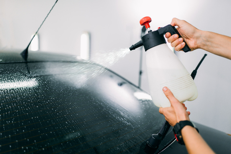 Male hand with spray, car window tint installationの写真素材