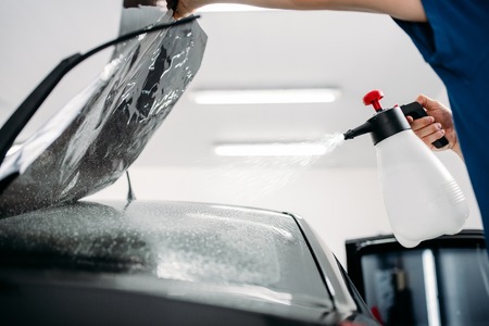 Male hand with spray, car window tint installationの写真素材