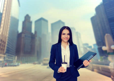 Business woman with notebook and coffee in handsの写真素材