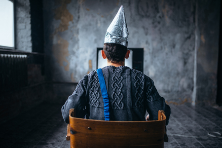 Man in tinfoil helmet watches TV, ufo phobiaの写真素材