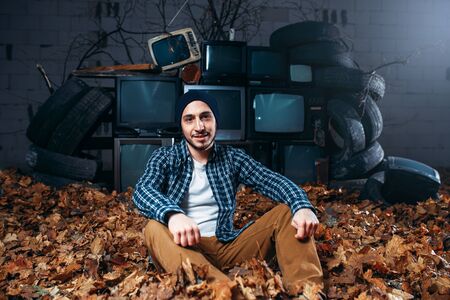 Stalker, mountain of old TVs on background