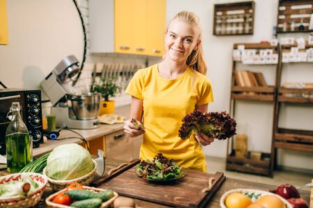 Happy woman holding salad, cooking healthy foodの写真素材