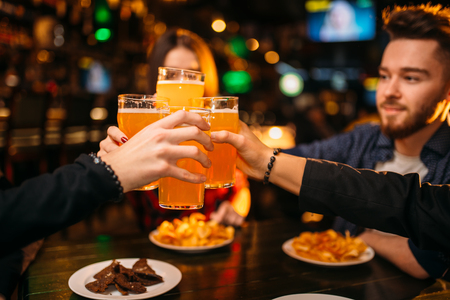 Fun company raised their glasses in a sport barの写真素材