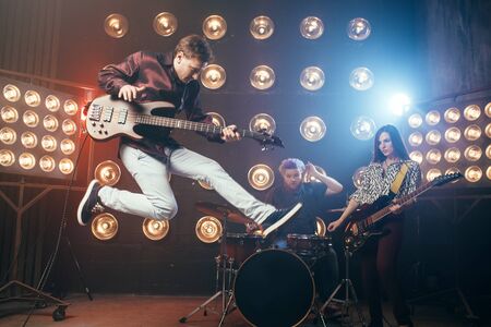 Guitarist plays on bas-guitar, snapshot in a jumpの写真素材