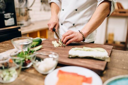 Male cook hands making sushi rolls, seafoodの写真素材