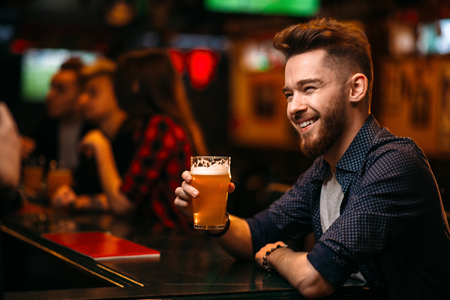 Man drinks beer at the bar counter in a sport pubの写真素材