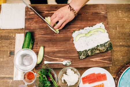 Male cook hands making sushi rolls, seafoodの写真素材