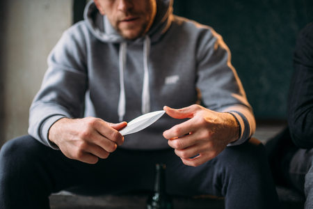 Male robber with knife sitting on the stairsの写真素材