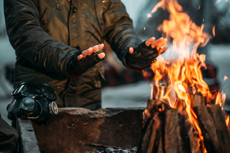 Stalker, male person warms his hands on fireの写真素材