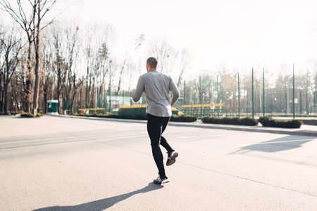 Jogger in motion, running in autumn parkの写真素材