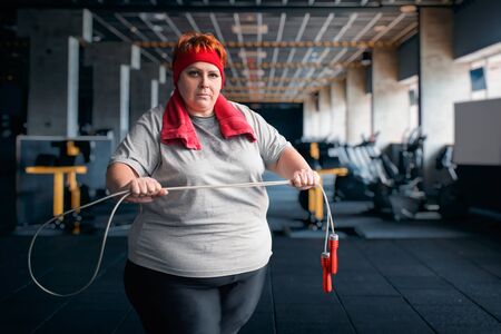 Fat sweaty woman, fitness exercise with ropeの写真素材