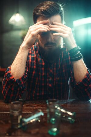 Sad man sitting at bar counter, alcohol addictionの写真素材