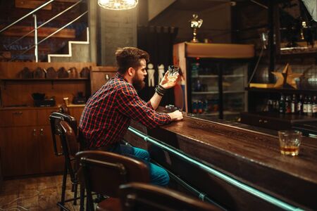Man sitting at the bar counter and drink alcoholの写真素材