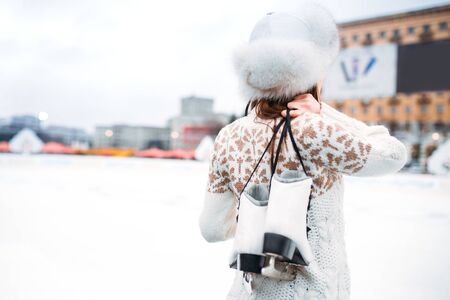 Young woman with skates in hands on skating rinkの写真素材