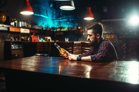 Man sitting at the bar counter, alcohol addictionの写真素材